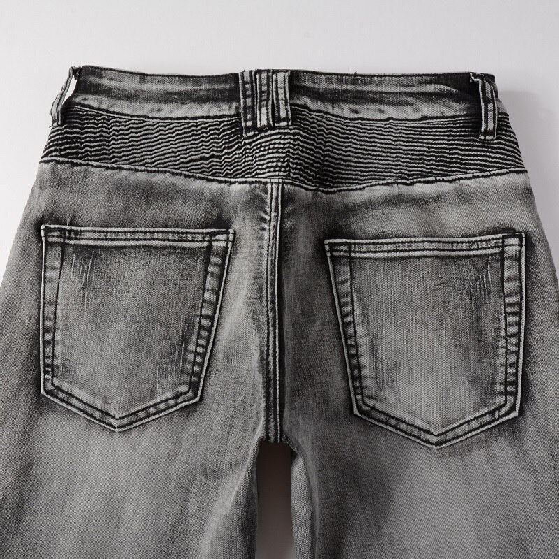 Men's distressed biker jeans with ripped patchworks, hollow out ribs, zippers, holes, and a grey washed slim stretch fit