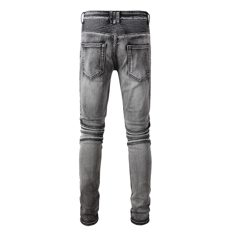 Men's distressed biker jeans with ripped patchworks, hollow out ribs, zippers, holes, and a grey washed slim stretch fit