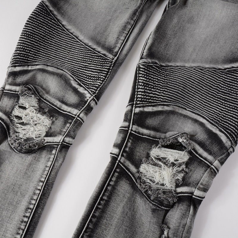 Men's distressed biker jeans with ripped patchworks, hollow out ribs, zippers, holes, and a grey washed slim stretch fit